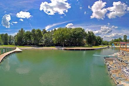 Naturbadesee umgeben von Bäumen