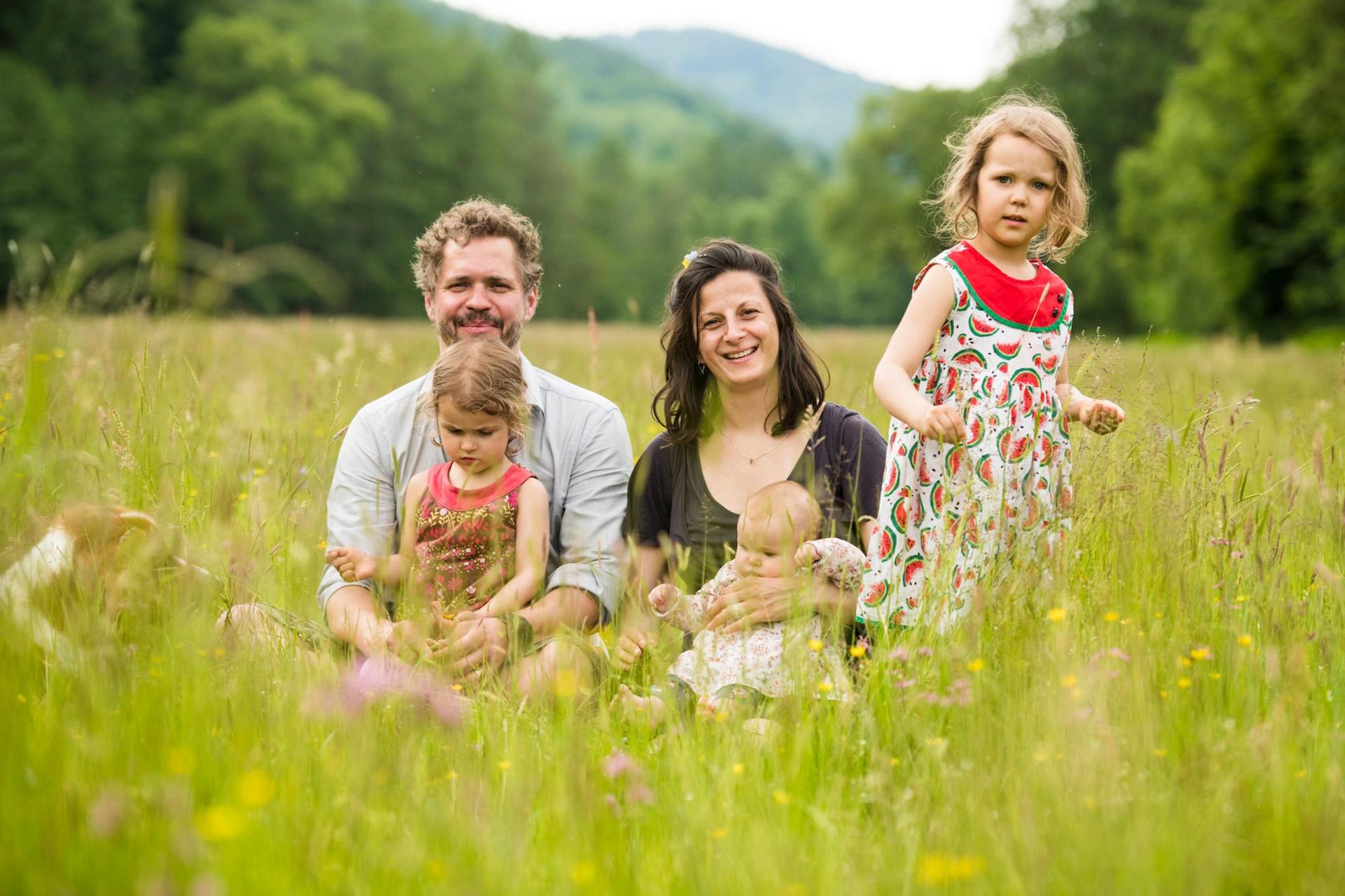Familie Bogensberger sitzend in einer Wiese