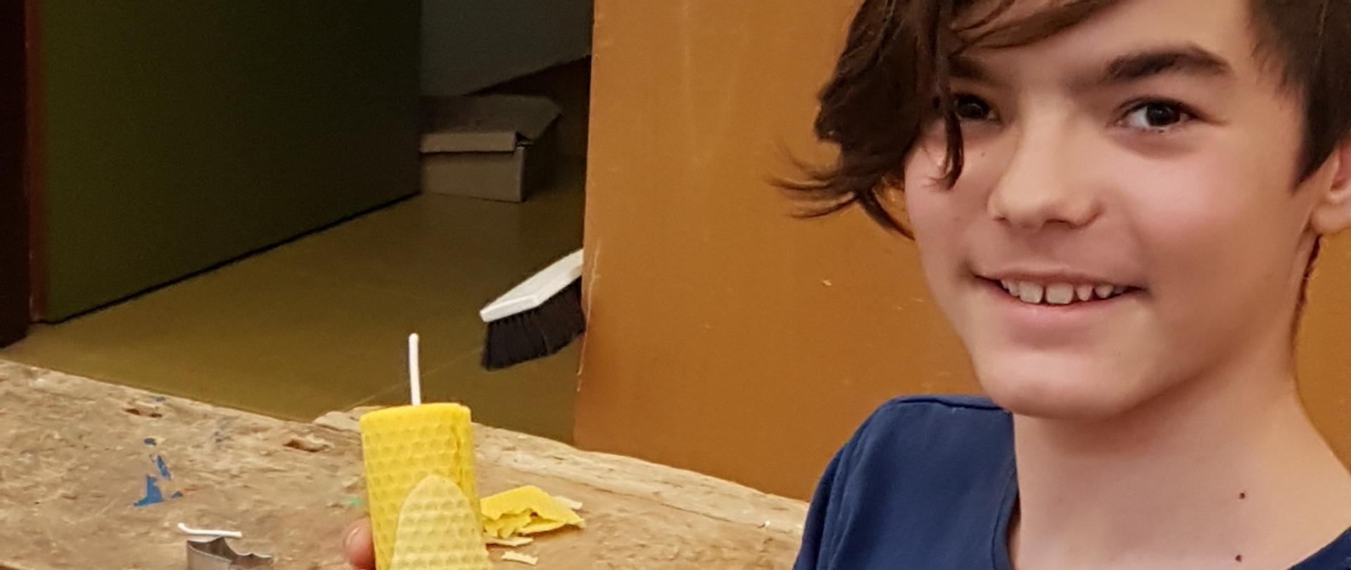 Kind mit gelber Wachskerze in der Hand