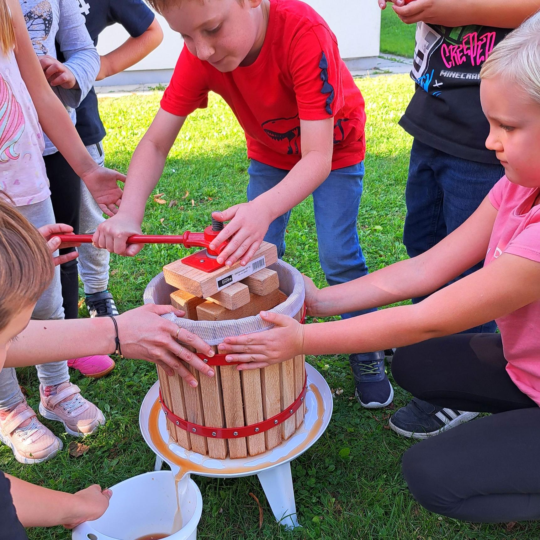 Kinder pressen Apfelsaft
