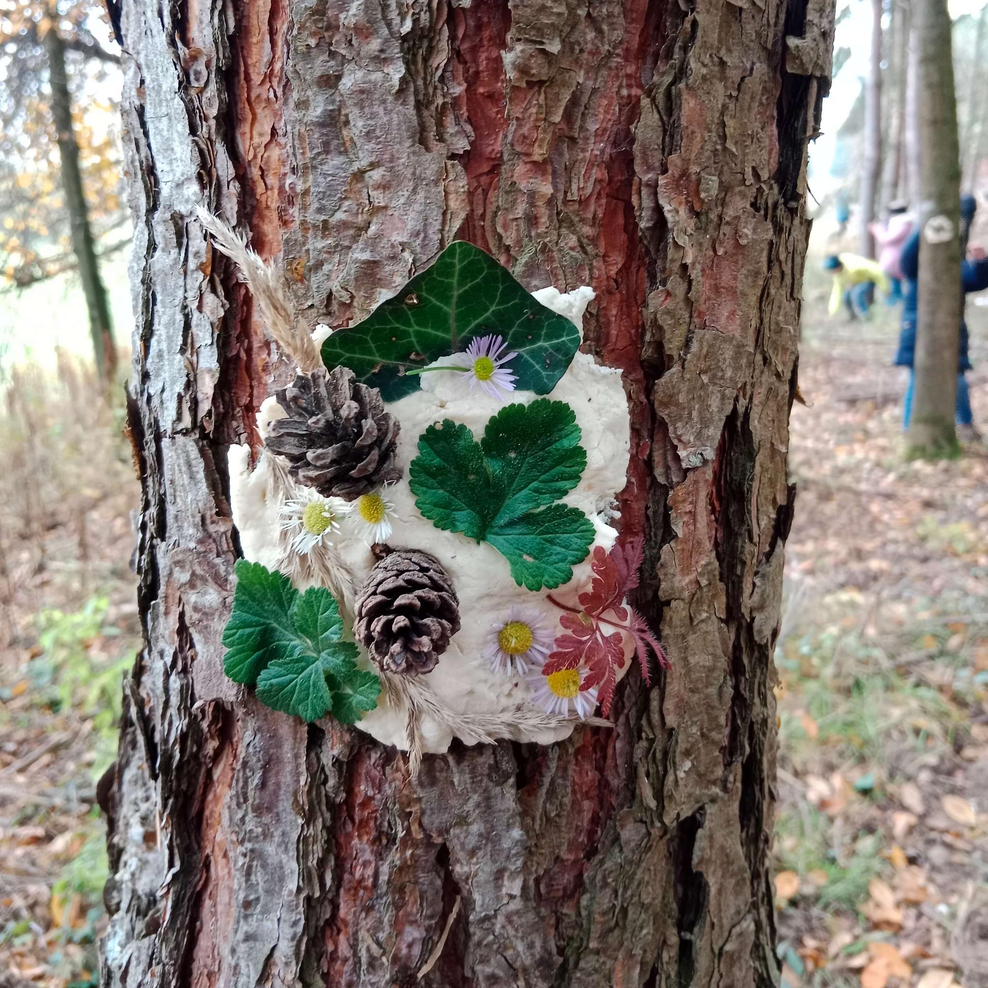 Waldgeist aus Salzteig auf Baumstamm