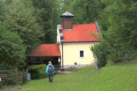 Kapelle im Wald mit Spaziergänger